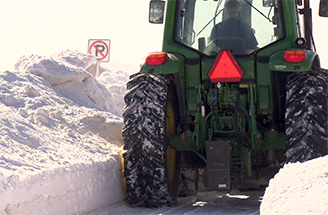 sidewalk unit plowing snow from a sidewalk