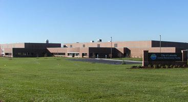 The Central Maintenance Facility, a large brick building with an expansive green lawn.
